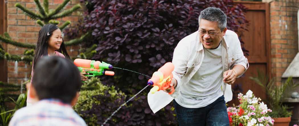 Dad and kids playing with water guns